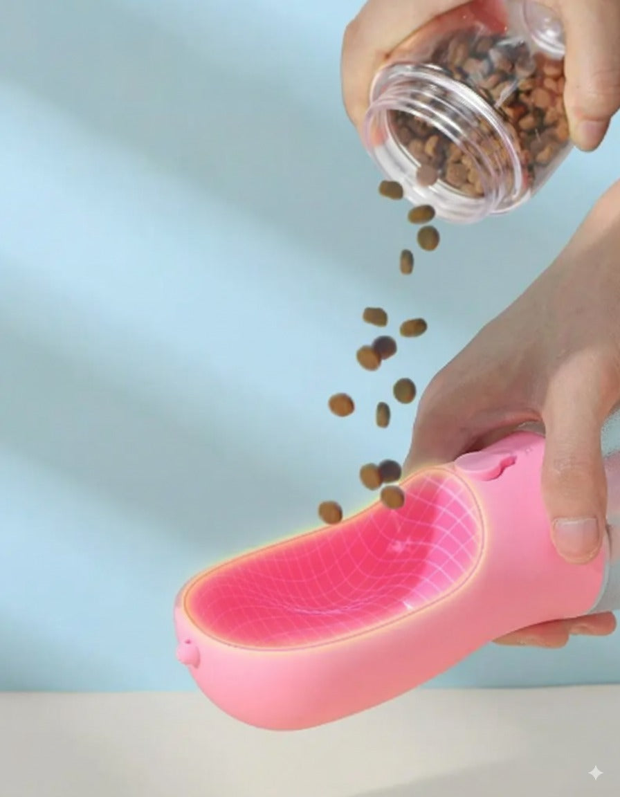 A person pouring dog kibble from the detachable snack pod directly into the wide cup of the pink portable pet bottle, showing it can be used as a food bowl.